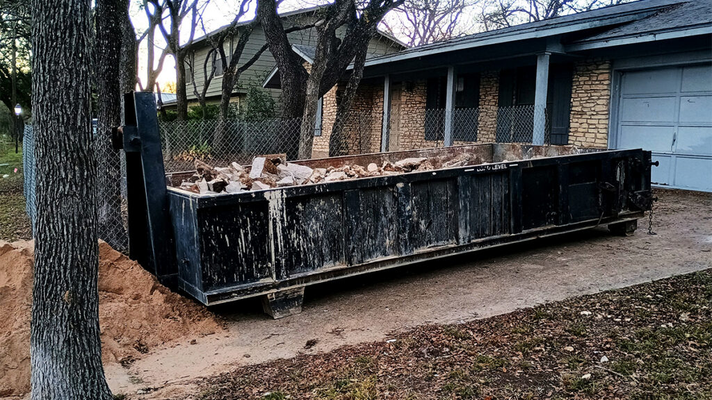 Dumpster in driveway loaded with heavy material
